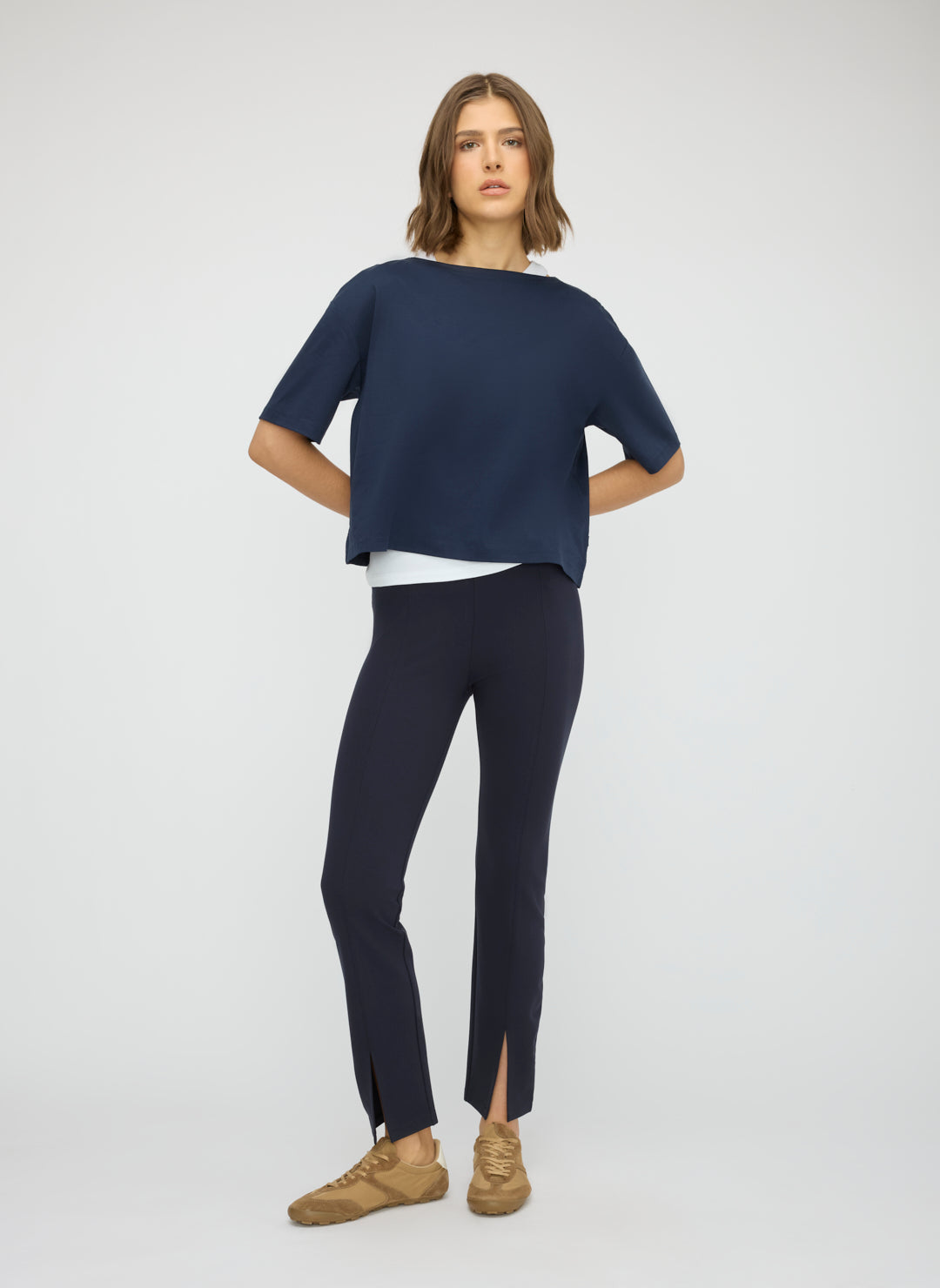 Woman wearing a navy blue top and pants on a white background